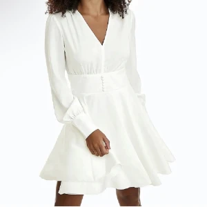 Vit klänning  - Jättefin vit oanvänd klänning. Fint skick med lappen kvar. Köpte till studenten men blev aldrig använd.  Stängd i ryggen. Vita klädda knappar som detalj vid armarna och midjan. Skickas fler bilder vid önskan. Pris kan diskuteras. 