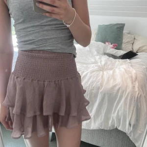 Kort volangkjol - Jättefin, somrig volangkjol i smutsrosa. Kan även användas som topp, endast använd fåtal gånger.