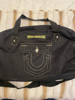 Säljer denna super snygga true religion weekendbag. Perfekt för att ha med sig över helgen, som handbagage eller som gymväska! 