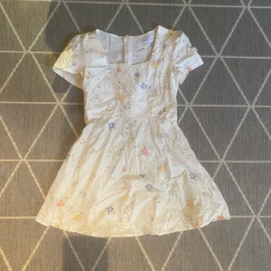 klänning blommor - världens finaste klänning !! blommor och en vit bakgrund. väldigt fin urringning. tyvärr för liten för mig .:(