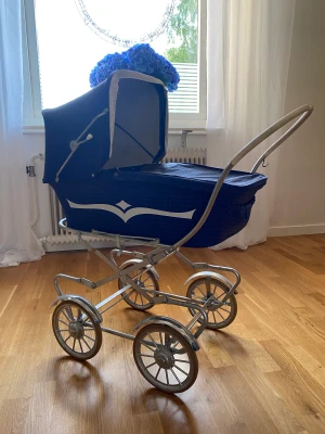 Retro dockvagn, liggvagn 1960-talet - Mkt fin dockvagn, liggvagn i blå venyl med tillhörande madrass. Inga repor på vagnen. Löstagbar sits