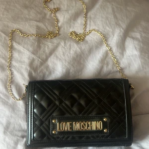 moschino väska - säljer min väska då jag köpt en ny, denna är använd enbart ett få antal gånger så jag skulle säga att den är i ny skick. Den är äkta och köpt för ca 1400kr dock har jag inget kvitto kvar.