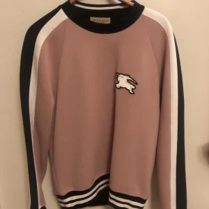 Sweatshirt från Burberry, Storlek S - Köpt på burberry.com för 3 år sen. Vit, svart och rosa med lite vintage-känsla men ändå modern. Tyvärr blir den för lång i ärmarna för mig så helt oanvänd. I längden som en vanlig S men längre i ärmarna. Bättre för nån lite mer bredaxlad. Nypris 5000kr.