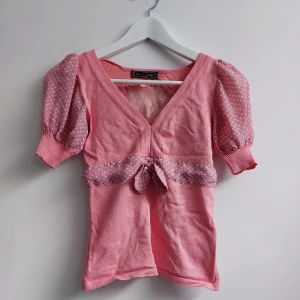 Topp - Rosa topp med mesh rygg och puff armar. Har ett litet hål på kragen på baksidan.