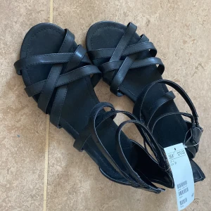 Svarta sandaler - Helt oanvända och nya sandaler från H&M.r i storlek 37. Säljer då storleken inte passar mig. Annars är se ursnygga. Nypris:129kr. Köparen står för frakten ❤️