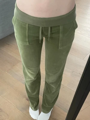 Gröna mjukisbyxor från Juicy Couture - (De är xs men funkar även som S, de är ju stretchiga så ksk M också men idk) gröna mjukisbyxor från Juicy Couture i mjuk velour med raka ben och bred resår i midjan. Byxorna har fickor fram och bak, varav bakfickorna har lock och knapp.
