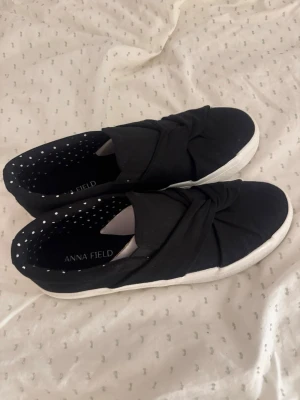 Svarta slip-on sneakers Anna Field - Snygga svarta sneakers från Anna Field. De är använda en gång men kommer ej till användning. Skorna är i storlek 37 men passar mig som har 37-38. Hör av er vid fler frågor💗