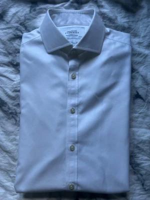 Vit skjorta från Charles Tyrwhitt - Klassisk vit skjorta från Charles Tyrwhitt i bomull. Skjortan har lång ärm, knappar framtill och en stilren krage. Perfekt till både jeans och kostymbyxor för en clean look.