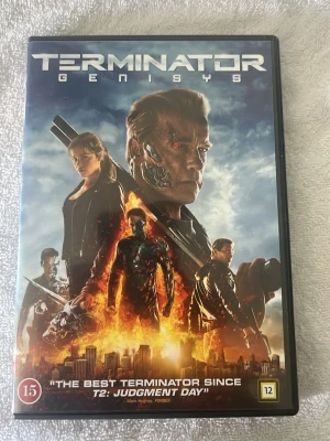 Terminator Genisys DVD med fodral - DVD med filmen Terminator Genisys i ett svart plastfodral. Omslaget har ett färgstarkt motiv med karaktärer från filmen och futuristiska detaljer. Skivan är silverfärgad med svart text. Perfekt för dig som gillar action och science fiction.