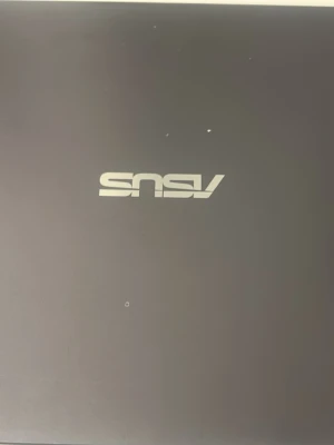 ASUS bärbar dator i mörkgrått - Snygg bärbar dator från ASUS i mörkgrå metallfinish. Datorn har en stor touchpad, fullstort tangentbord och en skärm med smala kanter. Perfekt för studier, gaming eller streaming. Klassisk och stilren design som passar de flesta behov.