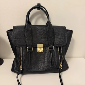 3.1 Phillip Lim Väska - Jättefin väska från 3.1 Phillip Lim Pashli Satchel Medium.   Den passar min 13” dator då är den perfekt för skolan eller jobb. Köpte från Vinted, förra ägaren köpte från Arkivet.  Säljer för 2000kr och kom gärna med bud.   Finns att hämta i Tyresö.