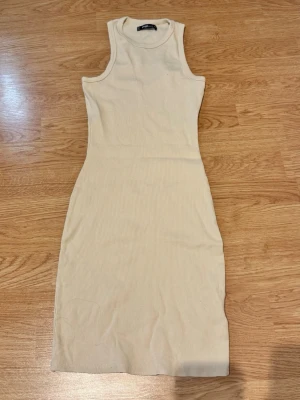 Beige tight kort klänning - Säljer en beige, tight och ärmlös kort klänning. I super bra skick💕storlek M men sitter som XS/S