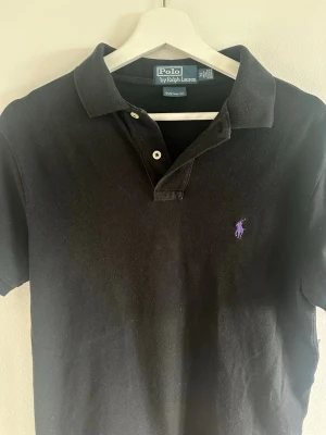 Svart piké från Polo Ralph Lauren - Klassisk svart piké från Polo Ralph Lauren. Vintage modell så svår att få tag på. Riktigt kap✅✅✅