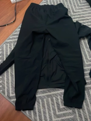 Svarta Nike Dri-FIT mjukisbyxor - Svarta mjukisbyxor från Nike med Dri-FIT-teknologi. Byxorna har resår i midjan och muddar vid bensluten för en skön passform. Perfekta för träning eller chill, med diskret Nike-logga och sportig look.PRIS KAN DISKUTERAS 