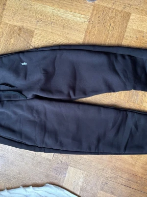 Svarta mjukisbyxor från Polo Ralph Lauren - Säljer ett par svarta mjukisbyxor från Polo Ralph Lauren med klassisk logga broderad på benet. Byxorna har dragsko i midjan och ribbade muddar. Perfekta för chill dagar och riktigt sköna tack vare det mjuka materialet.
