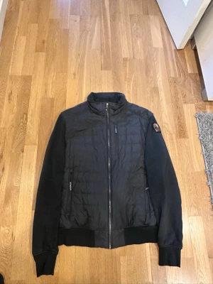 Svart pufferjacka från Parajumpers - Säljer en svart ÄKTA pufferjacka från Parajumpers med quiltad framsida, ribbade muddar och hög krage. Mycket bra skick (2 små hål som finns på annonsen. Utöver inga problem. Pris är EJ hugget i sten (äkta) 
