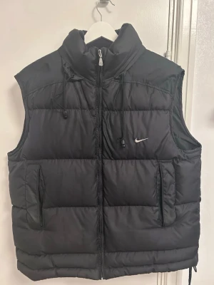 Vintage Nike väst - Sällsynt vintage Nike väst köpt på en vintage Instagram sida för 1299kr. Bra skick. Västen har även en inbyggd huva som enkelt kan tas fram eller stoppas undan i kragen beroende på väder.