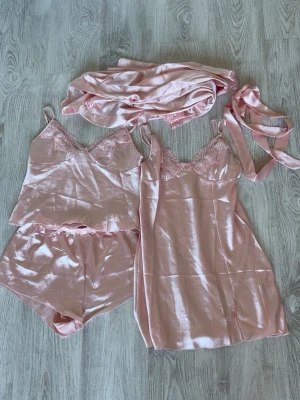 Rosa pyjamasset från SHEIN - Säljer ett rosa pyjamasset från SHEIN i storlek XS. Varken nattlinnet eller morgonrocken har använts💕Kolla in min profil för fler fina och trendiga plagg!
