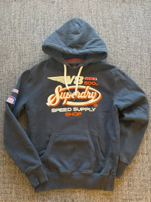 Superdry hoodie  - Säljer nu denna sjukt eftertraktade hoodie ifrån Superdry. Skick 9/10, sjukt snygg och passar perfekt nu till våren! Obs kan gå ner i pris vid snabb affar!