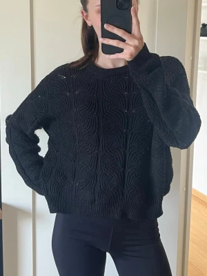 Svart stickad tröja Vero Moda - Säljer en svart stickad tröja från Vero Moda med ett coolt vågigt mönster. Tröjan har rund halsringning, långa ärmar och ribbade muddar. Perfekt till jeans eller tights för en avslappnad look.
