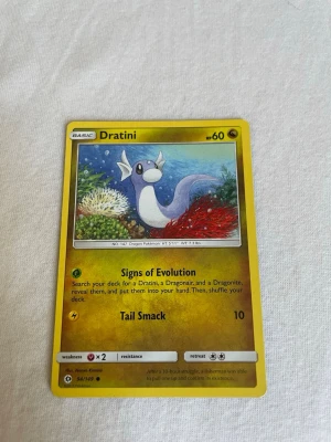 Pokémonkort Dratini 94/119 - Samlarobjekt! Pokémonkortet Dratini 94/119 med gul ram och färgglad illustration. Kortet har HP 60 och visar Dratini i undervattensmiljö. Perfekt till dig som gillar Pokémon eller vill utöka din samling.