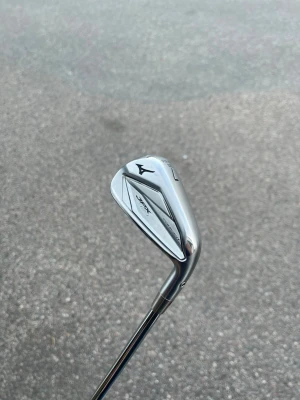 Mizuno JPX 921 golfklubba järn 7 - Säljer en Mizuno JPX 921 järn 7 golfklubba i silverfärgat stål. Klubban har en modern design med Mizuno-loggan och tydliga markeringar. Perfekt för dig som vill ha ett kvalitetsjärn till golfbanan.
