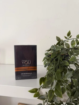 Emporio Armani Stronger With You Intensely - Helt ny och oöppnad Stronger With You Intensely från Emporio Armani är en parfym i en elegant mörkbrun kartong med guldiga detaljer. Förpackningen är stilren och modern, och parfymen är känd för sin intensiva och kraftfulla doft. Perfekt för dig som vill ha en unik och minnesvärd signaturdoft.