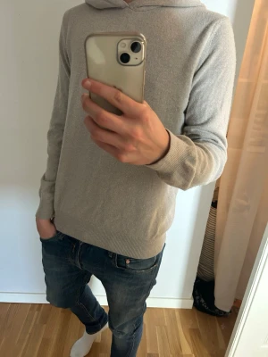Ljusgrå hoodie från Oscar Jacobson - Snygg ljusgrå hoodie från Oscar Jacobson i mjukt och tunt material. Klassisk modell med huva och ribbade muddar vid ärmslut och nederkant. Perfekt för en avslappnad och stilren look. Kom vid frågor.