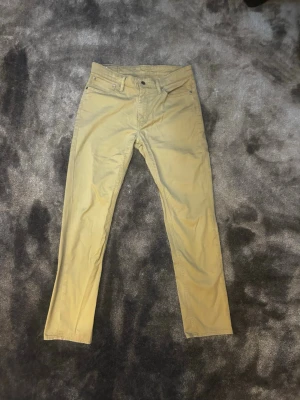 Beige 511 jeans från Levi's - Snygga beige jeans från Levi's 511 med slim fit passform och fem fickor. Jeansen är i storleken W33 L32. 