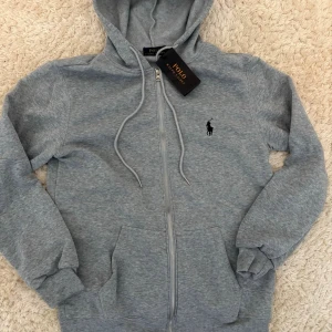 Grå hoodie  - Snygg grå hoodie med dragkedja. 