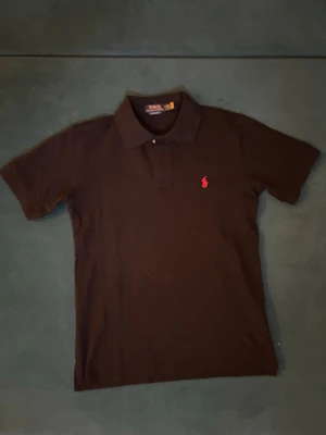 Svart polotröja från Polo Ralph Lauren - Klassisk svart polotopp från Polo Ralph Lauren, toppenskick. 🛑Skriv vid funderingar.                  🛑Snabb affär=kan gå ner i pris