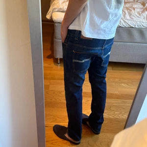 Mörkblå Nudie Jeans Thin Finn - Storlek: W34 L34. Modell: Thin Finn. Bra skick förutom hål i höger ficka (finns bild) går såklart att sy men pallar ej. Annars inga defekter 