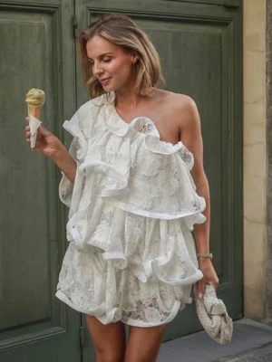 Vit spetsklänning med volanger - Superfin vit kort klänning i spets med stora volanger och oneshoulder-design. Säljer denna SUPER vackra klänningen från Lojsans kollektion med NAKD, säljer den eftersom jag hittat en annan klänning till studenten som jag gillar mycket mer! Jag bär vanligtvis S och den sitter bra på mig. Kan skicka egna bilder vid frågan.