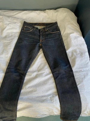 Nudie selvedge jeans Lean Dean 29/30 - Säljer ett par mörkblå dry Japan selvedge jeans från Nudie Jeans i storlek 29/30 (skulle påstå att nudies längd känns lite längre än andra märken). De är nya och aldrig tvättade, endast testade. Nypris ligger på 2500 kr på deras egna hemsida. Hör av er vid frågor och funderingar!