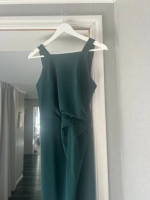 Mörkgrön klänning - Bubbleroom  - Stilren mörkgrön klänning med breda axelband och snygg drapering framtill. Klänningen har rak passform och ärmlös design, nypris 899kr säljer för 350, hör av dig vid frågor eller funderingar!😊