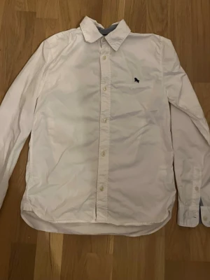 Vit skjorta med broderad logga - Klassisk vit skjorta. Perfekt för en clean look.