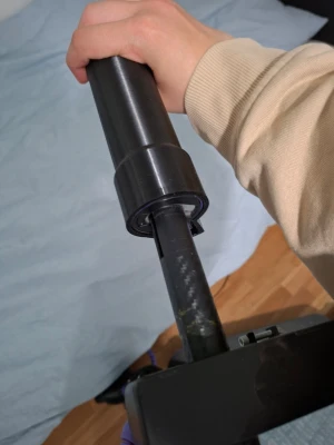 Svart plastadapter till elsparkcykel - Säljer en svart plastadapter som passar till styret på en sparkcykel eller elscooter. Adaptern har en cylindrisk form med ett litet handtag på sidan och är tillverkad i hård plast. Perfekt för dig som behöver en reservdel eller vill modifiera din scooter. Kan sänka pris
