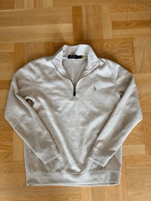  Halfzip Polo Ralph Lauren - Snygg beige tröja från Polo Ralph Lauren med halvzip och broderad logga på bröstet. Tröjan har hög krage, långa ärmar och ribbade muddar. Perfekt för en clean och stilren look. Öppen för pris förslag fråga vid minsta fundering 💭🤝🙌😁