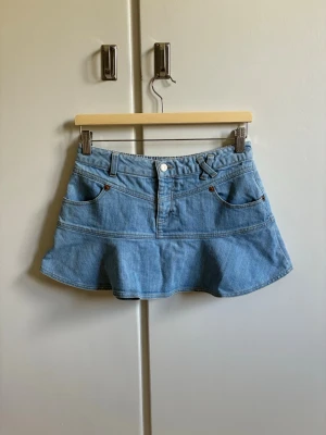 Blå jeanskjol - Jättesnygg ljusblå jeanskjol, perfekt för sommaren och skolan. Aldrig använd och därmed inga defekter. Midjemått (rakt över): 36 cm💓