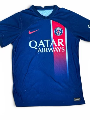 PSG matchtröja storlek L Unisex - Snygg blå PSG matchtröja. Har några blå färgfläckar på sig men jag tycker de matchar in i designen så inget man riktigt störs av. Storlek L men passar mindre också. 