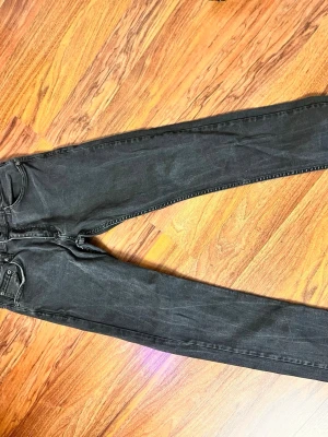 Svarta skinny jeans från H&M - Snygga svarta skinny jeans från H&M med klassisk femficksdesign och normal midja. Jeansen har smal passform och är tillverkade i stretchigt denim för extra komfort. Perfekta för en trendig och avslappnad stil.