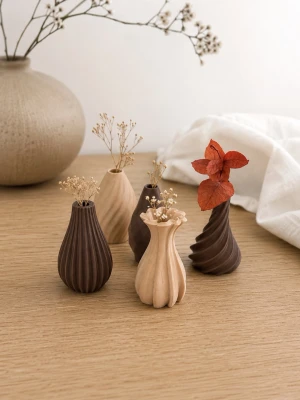 Set med små dekorativa minivasar - Säljer ett set med fem små cirka 2 cm höga dekorativa minivasar i olika former och mönster. Vaserna är i bruna och beige nyanser och har en modern, skulptural design. Perfekta för torkade blommor eller som inredningsdetalj på skrivbordet eller hyllan.