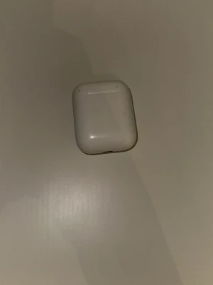 Apple AirPods med laddningsetui - Säljer ett par vita Apple AirPods gen 1  med laddningsetuiet dom laddar helt perfekt håller batteriet ända problemet är att den högra AirPoden brusar litegrann när man har max volym om det e mycket bass i det man på dom kommer som dom kommer inget kvitto på dom och ingen kartong har haft dom länge det e därför jag har tappat bort kartongen och kvittot 