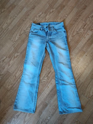 Ljusblå bootcut jeans - Säljer ett par ljusblå bootcut jeans med klassisk femficksdesign och utsvängda ben. Jeansen har en snygg tvättad look och normal midja. Perfekta för dig som gillar retrostil och vill ha ett par jeans med lite extra attityd. Äkta Lee jeans stl W28, benen är uppsydda i JC butiken där dom köptes, passar min längd 162cm.
