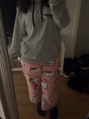Hello Kitty rosa pyjamasbyxor - Supergulliga rosa pyjamasbyxor med Hello Kitty-motiv. Byxorna är lösa och har ett lekfullt mönster med vita och rosa detaljer. Perfekta för mysiga hemmakvällar eller när du bara vill chilla.( skriv privat för mer bilder)