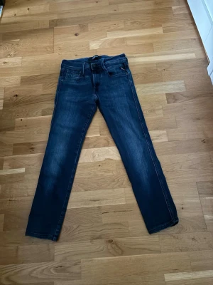 Replay anbass  - Snygga mörkblå slim fit jeans med klassisk femficksdesign och lätt slitna detaljer på framsidan. Jeansen har normal midja och raka ben. Perfekta för en trendig och avslappnad look. W27 L30. OBS ❗️men de är upplagda av skräddare, se mått på bilderna. Hör av er vid frågor!