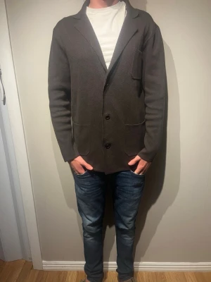 Mörkbrun stickad kavaj från john henric - Brun stickad kavaj ifrån john henric. Storleken är. S. Kavajen fungerar både med och utan hoodie. Kavajen är i nyskick. Modellen är 177cm och väger 65kg. Skriv för mer info