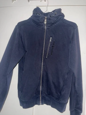 Marinblå hoodie från Sail Racing - Passar kvinnor och män.