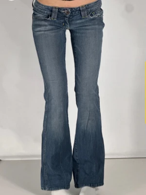 Blå bootcut jeans med låg midja - Ett par blåa bootcut jeans från guess som är köpta på tinlesell. Dom är aldrig använda av mig och säljer då dom tyvärr var lite för korta. Midjemått rakt över: 35 cm Innerbenslängd: 80 cm Grenhöjd: 15 cm 🩷