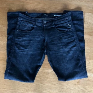 Replay jeans svarta - Säljer ett par svarta slim fit jeans från Replay med snygga slitningar framtill och klassiska fem fickor. Jeansen har en diskret logga på fickan och patch bak i midjan. Perfekta för dig som gillar en modern och stilren look. Det är bara att hör av dig vid minst lilla fundering!🙌